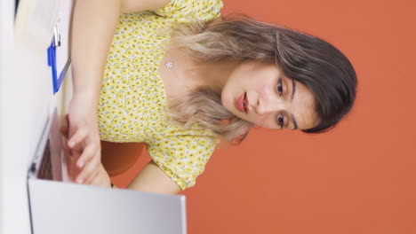 Vertical-video-of-Young-woman-looking-at-laptop-in-amazement.